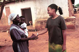 A volunteer and a local shake hands.