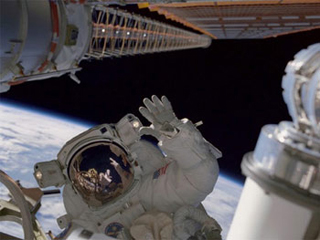 Photo of an astronaut in space with the Earth behind.